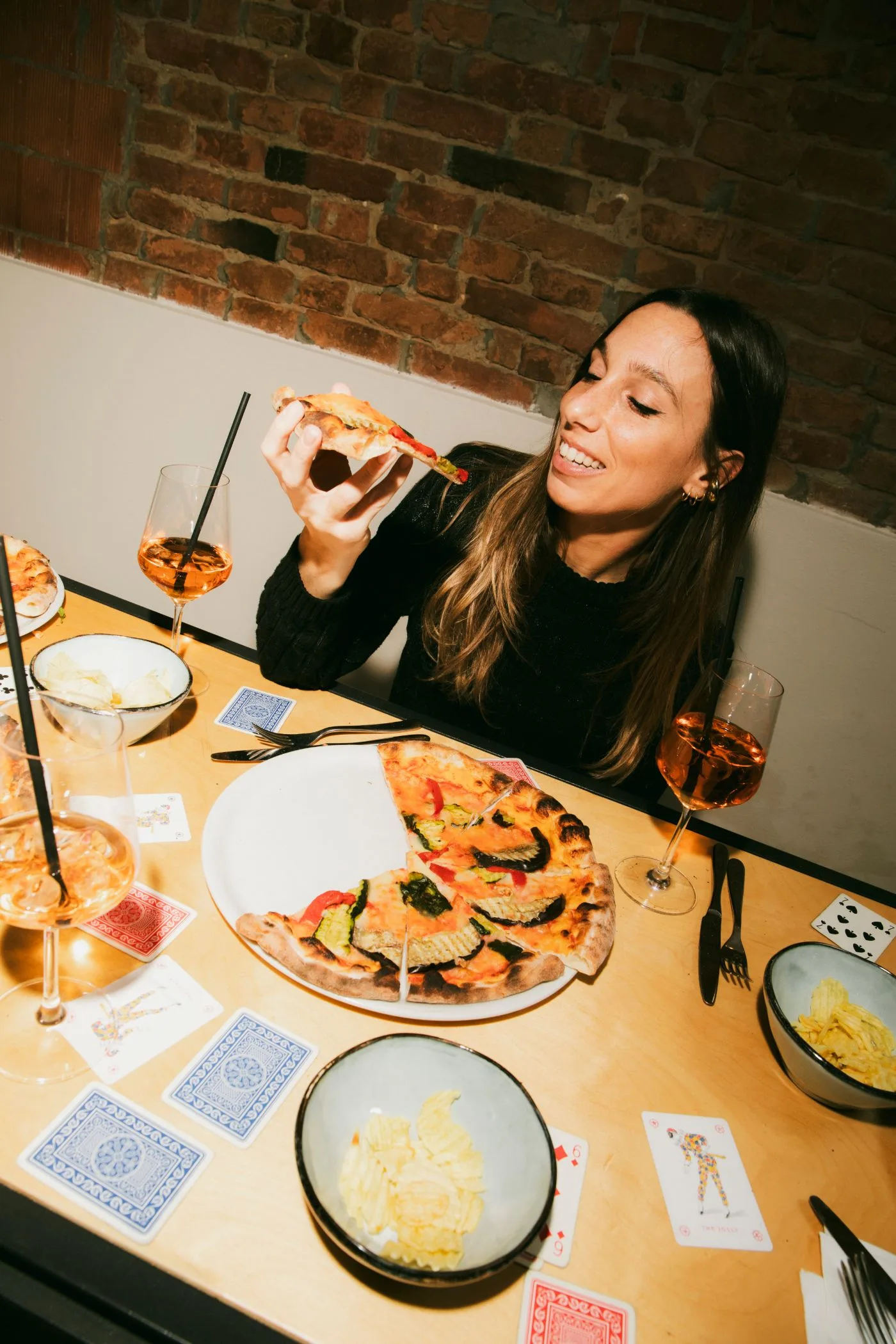 Ragazza gusta una pizza con un aperitivo al Jolly Blu di Villastrada
