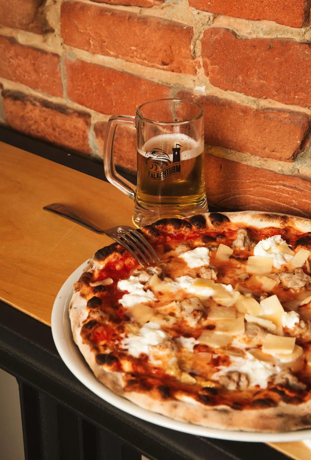 Birra alla spina Falkenturm accanto a una pizza al Jolly Blu